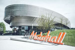  Die KTM Motohall am Stammsitz Mattighofen bietet für jeden Besucher ein einzigartiges Erlebnis. Perforierte Metallbänder, ein Sinnbild von Reifen­abdrücken, umkurven den modernen Stahlbetonbau 