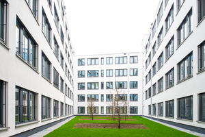  Das Werkquartier 1 schließt in seiner Mitte ein begrüntes Atrium ein – als ­Regenerations- und Pausenzone für die Mitarbeitenden. Die zum Atrium hin weiß verputzte Innenfassade sorgt für einen überraschenden Kontrast und eine freundliche, helle Aufenthaltsatmosphäre 