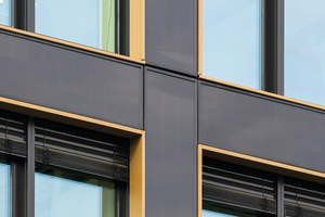  Die bronzefarbenen Einfassungen der Fenster bilden einen dezenten Kontrast zum annähernd schwarzen Farbton der Fassadenelemente. 