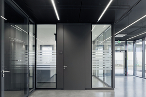  Die moderne architektonische Bauweise in Sichtbeton setzt im Innern des Verwaltungstraktes auf Terrazzoboden und schwarze Furaldecken-Elemente sowie auf transparente Trennwandsysteme mit raumhohen Wand- und Türelementen.  