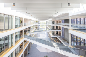  Das lichtdurchflutete Gebäude mit seinen offenen Fluren und eleganten Glasgeländern überzeugt durch eine klare, minimalistische Architektur, die Transparenz und Funktionalität harmonisch vereint. Ein besonderes gestalterisches Highlight ist die vertikal ­montierte Akustiklösung Ecophon Solo Baffle. Sie setzt sowohl akustisch als auch ästhetisch Maßstäbe und bildet ein besonderes ­gestalterisches Highlight der beeindruckenden Magistrale. 