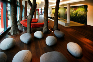  Hier sind nur die Steine nicht „natürlich“: Das Foyer der&nbsp; bietet unter anderem eine mit 2350 lebenden Pflanzen bestückte grüne Wand und arbeitet mit sieben Baumstämmen als Raumteiler 