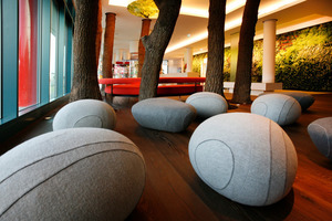  „Steine“ aus Filz laden im Foyer dazu ein, zu verweilen. Für ein angenehmes Raumklima und eine tolle Atmosphäre sorgen u. a. echteBaumstämme 